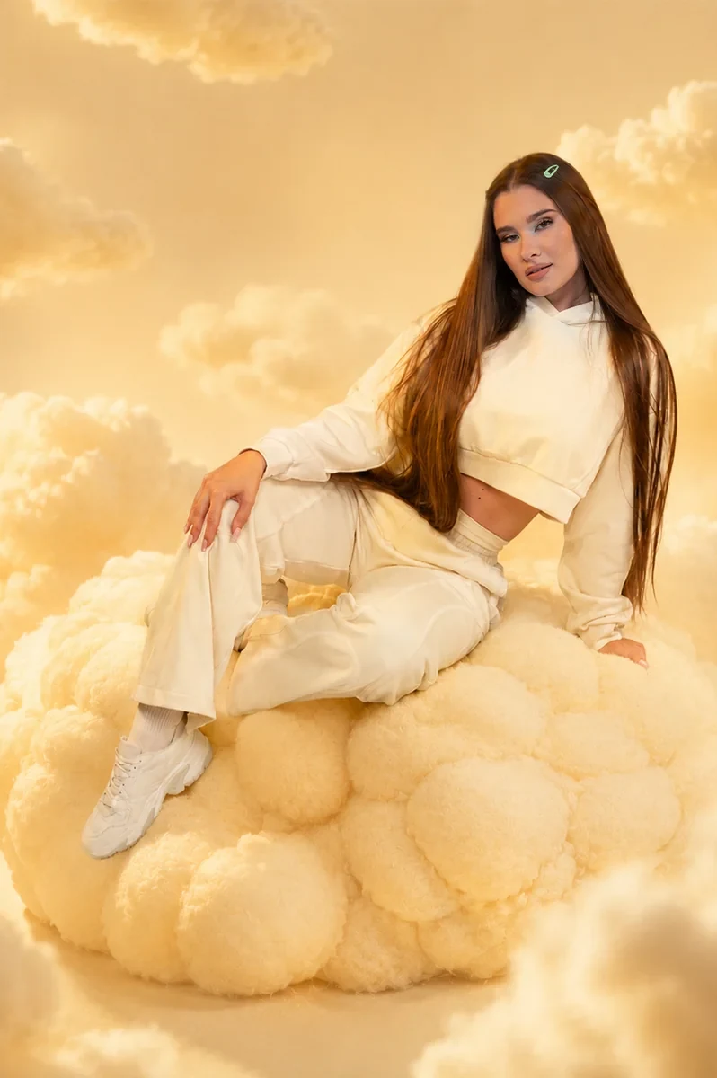 Nach der KI-Postproduktion: GymBeam-Model auf einer goldenen Wolke