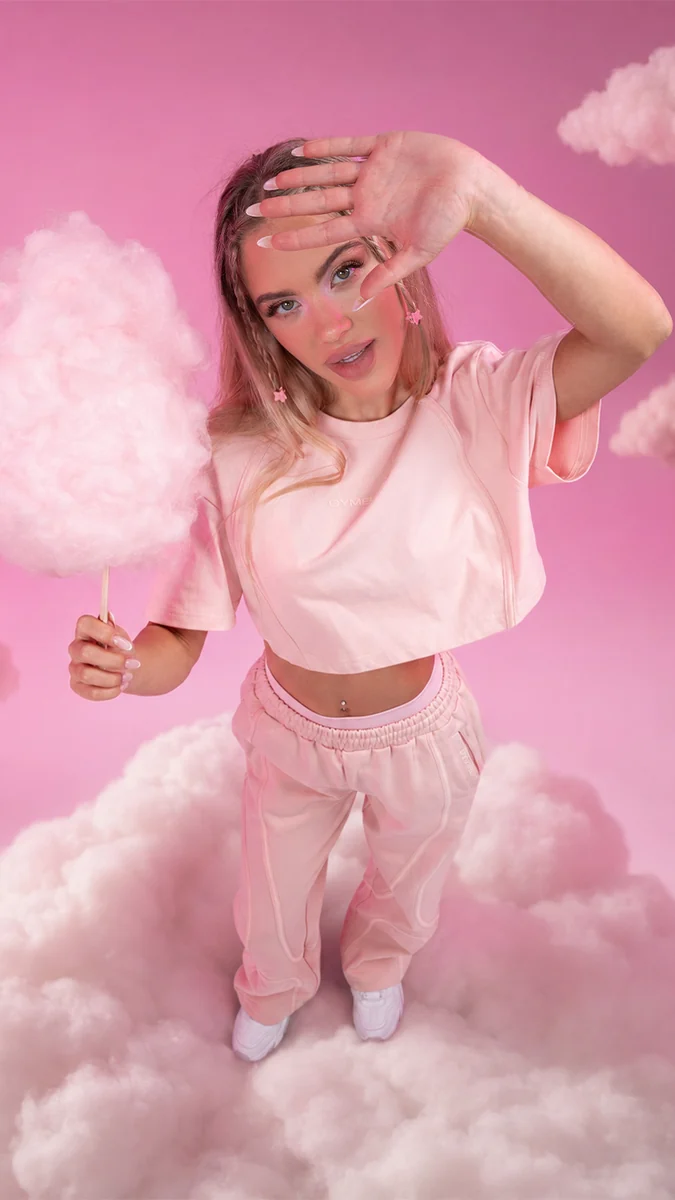 Nach der KI-Postproduktion: Model mit Zuckerwatte in rosa Wolken