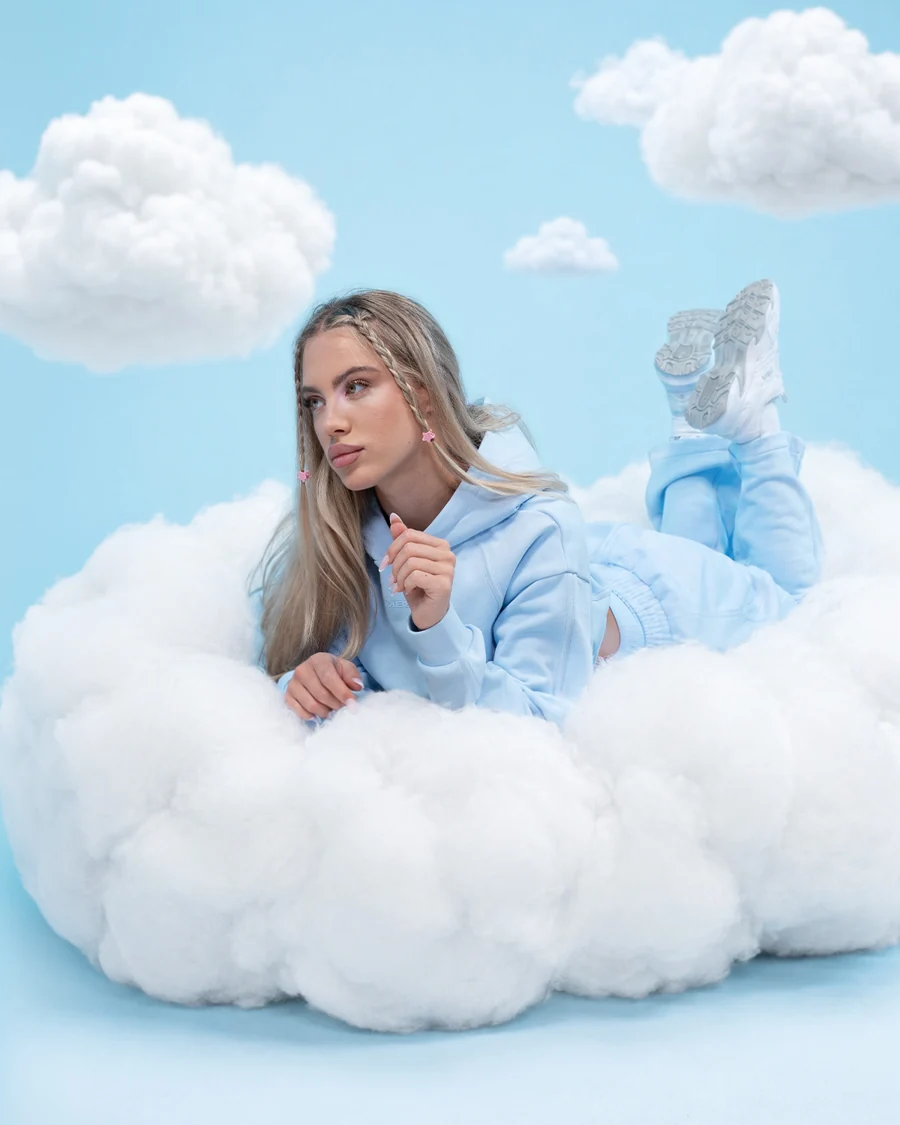 GymBeam-Model in einem blauen Outfit auf einer Wolke
